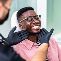 Dentist looking at patient's smile in treatment chair