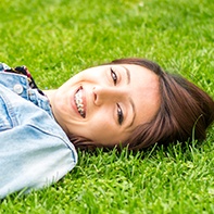 Teen with braces laying outside