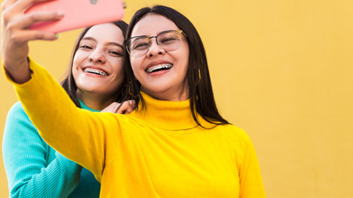 Two young women with braces taking a selfie