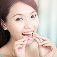 Woman placing Invisalign tray