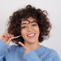 young woman holding Invisalign clear aligner 