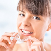 Woman placing Invisalign tray