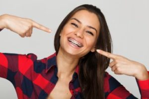 Smiling woman pointing at her braces