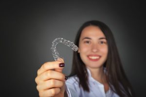 girl holding Invisalign