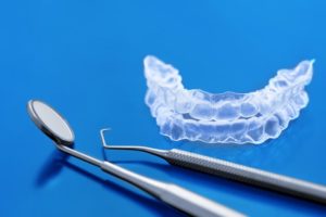 Invisalign aligners next to dental tools