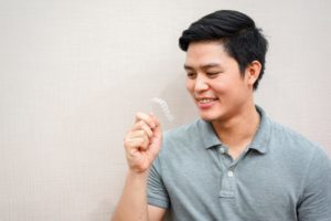 Teen in grey polo holding Invisalign in Canfield