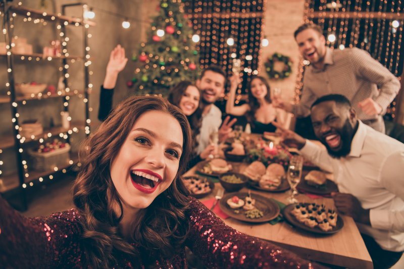 Woman with Invisalign smiling with her family during holidays