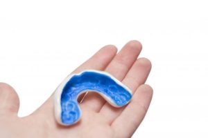 a child holding a protective mouthguard